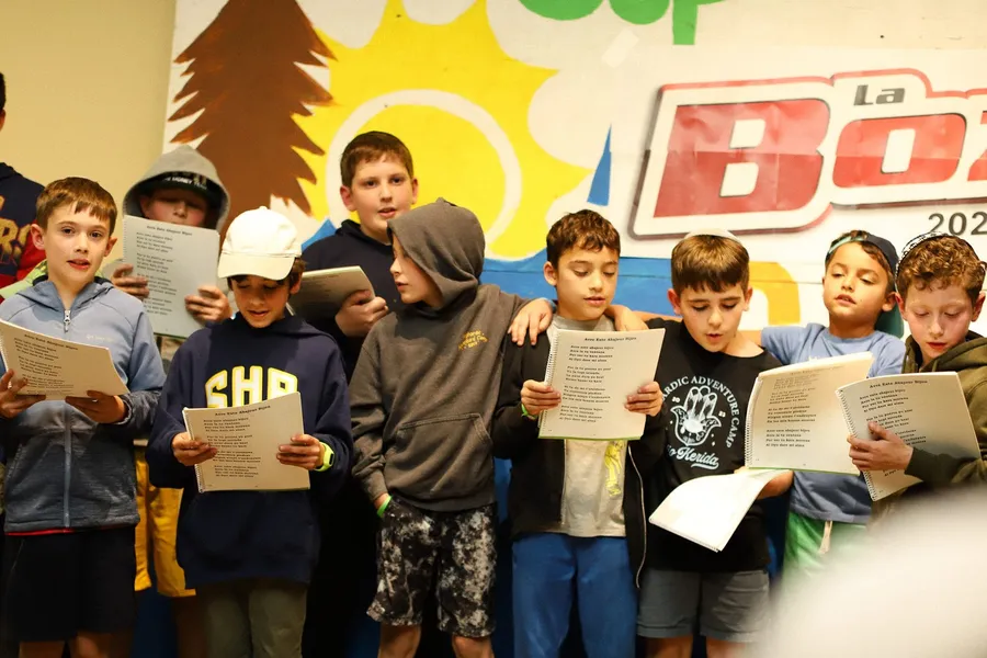 Campers singing from printed songbooks