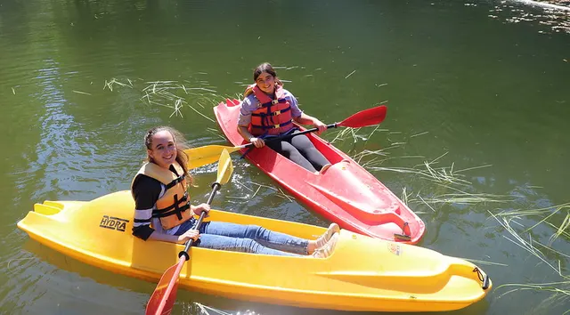 Campers paddling funyaks on the water